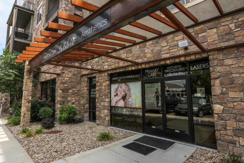 The La Belle Vie entrance in Draper seen from the sidewalk, with its stone front, orange pergola and landscaped gravel bed
